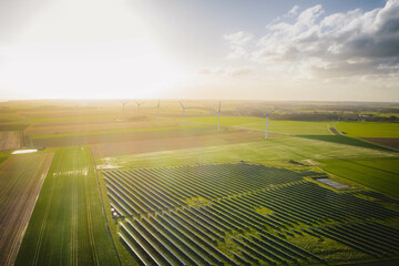Wind turbines and solar panels farm in a field. Renewable green energy. Sunny landscape, electric...