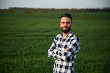 Spring season. Handsome young man is on agricultural field