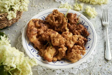 Fried European elder blossoms on a plate with a fork