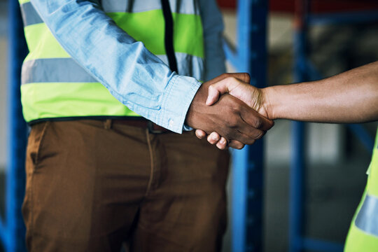 People, architect and handshake in construction, building or hiring in teamwork partnership on site. Contractor men shaking hands in recruiting, architecture agreement or industrial deal at warehouse