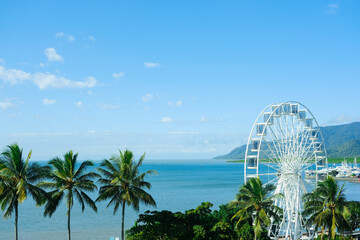 Blue skies and the  clear turquoise waters of the Coral Sea framed by palm trees at Cairns Esplanade — Far North Queensland, Australia - obrazy, fototapety, plakaty