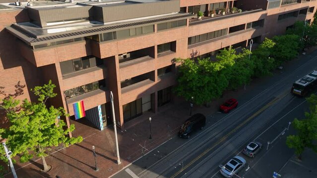 High up shot of a pride flag hanging over Seattle Central's main entrance in the morning glow.
