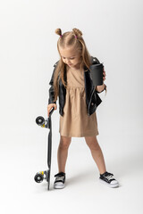 Stylish little girl child with skateboard over white background, Space for advertising