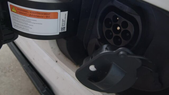 plugging off charging cable on electric car