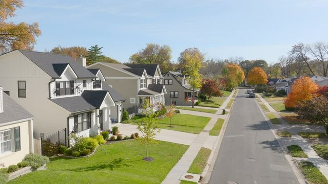 Rise up over nice residential neighborhood street with new construction houses on a sunny day in Autumn.
