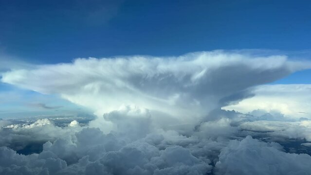 Impressive stormy cumulonimbus cloud with the perfect shape of an anvil. A pilot’s perspective flying at 12000m high.
