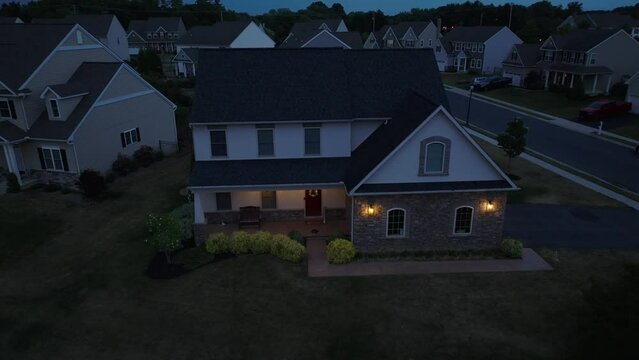 Exterior view of American home at night. Aerial establishing orbit shot at dusk.