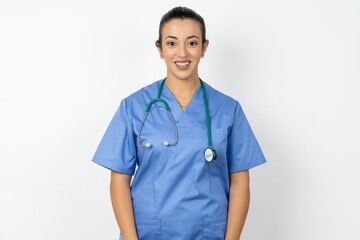 Close up photo of Beautiful doctor woman standing over white studio background toothy smiling