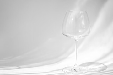 Empty wine glass with beautiful light pattern on background