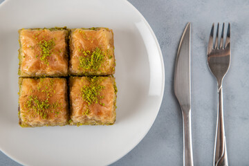 Pistachio baklava on a white plate.A plate baklava on light blue  background