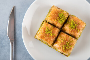 Pistachio baklava on a white plate.A plate baklava on light blue  background
