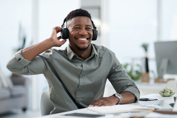Black man, headphones and listening to music in office with smile for sound track or podcast. Happy African male person or professional designer smiling with headset enjoying audio at the workplace