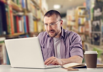 Happy young business man using laptop