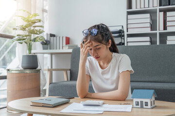 Stressed young woman calculating monthly home expenses, taxes, bank account balance and credit card bills payment, Income is not enough for expenses