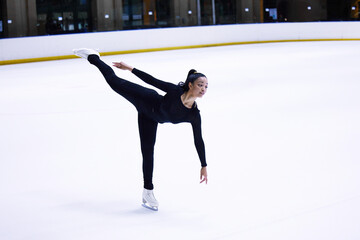 Fototapeta na wymiar Sport, woman athlete figure skating and at a sports arena on ice floor. Fitness training or exercise, balance or health wellness and female person skate for competition or tournament in sportswear