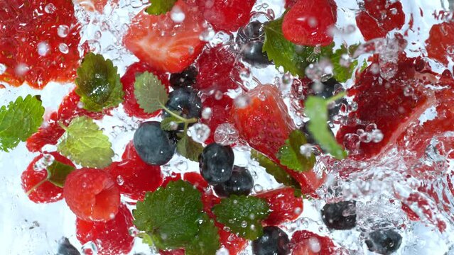 Super Slow Motion Shot of Fresh Berries Falling into Water Whirl at 1000 fps.