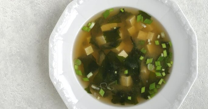 Homemade authentic miso soup with kombu dashi, tofu, wakame seaweed and scallions. Table spin.