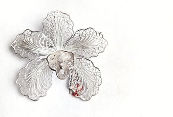 Filigree silver brooch with orchid motif isolated on white background. - obrazy, fototapety, plakaty
