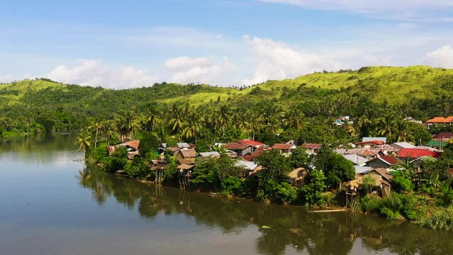 River and green hills. Beautiful natural scenery of river in southeast Asia. Countryside on a large tropical island. Small village on the green hills by the river. The nature of the Philippines, Samar