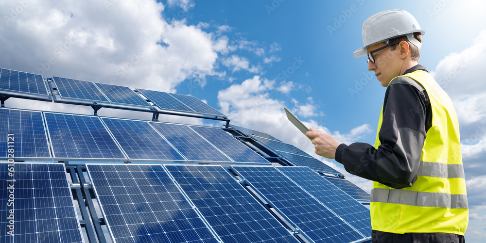 Poster Engineer with tablet computer on a background of mobile solar energy power station