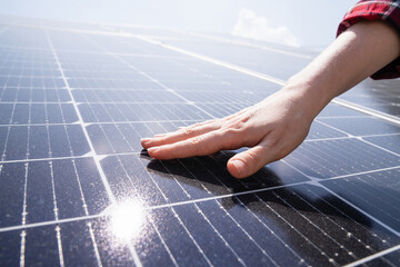 Close-up of a hand touching a solar panel