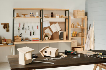 Horizontal image of workshop to build birdhouse from wood with objects and tools on table
