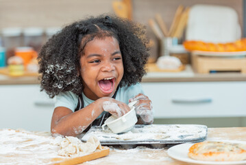 african afro black daughter kids sifting flour powder and sprinkling ingredients on massaging dough for bakery cooking. Black african daughter afro hair enjoy sifting flour wheat by sieve in kitchen