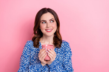 Portrait of pretty positive lady toothy smile arms hold fresh coffee cup look empty space isolated on pink color background