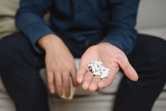 the person using drug overdoses. close up on pills in hand.