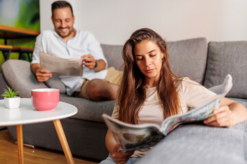 Couple reading newspaper and drinking coffee