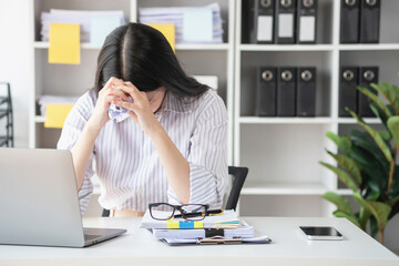 Concept Burnout Syndrome. Asian business Woman feels uncomfortable working. Which is caused by...