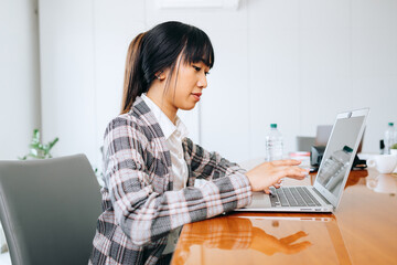 Portrait of a beautiful Asian businesswoman working using computer in a modern office.