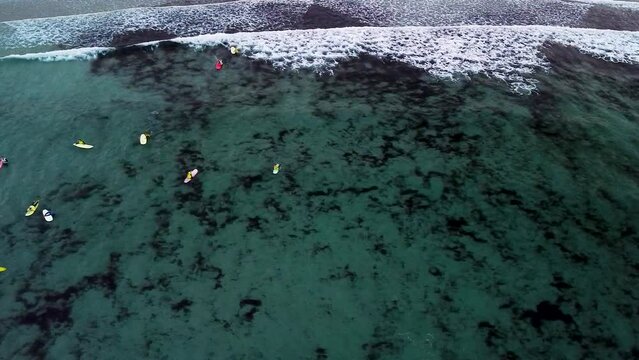 Surfers On The Surfing Sea Waves In Caion, Galicia, Spain. Aerial Drone Shot