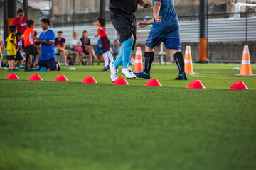 Obraz premium Soccer ball tactics on grass field with cone for training children running