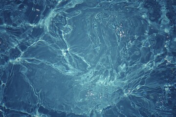 Blue water with ripples on the surface. Defocus blurred transparent blue colored clear calm water surface texture with splashes and bubbles. Water waves with shining pattern texture background.