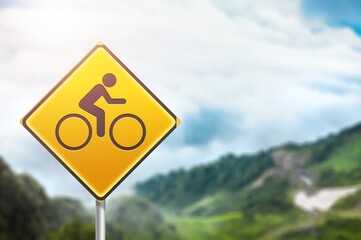 Round bicycle yellow sign on sky background.