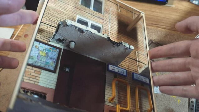  A master of miniatures showcases a small brick wall with a window, an integral part of a diorama. 
 The process of creating a miniature diorama and a model.