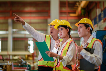 Factory apprenticeship. Header mentor teaching young employees trainee operating machine looking...