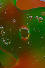 Oil on water with a coloured background.