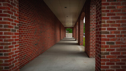 Corridor of the building. Architectural red brick columns, diminished perspective of the walkway in an old building