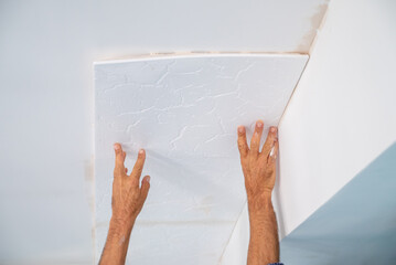 adhesive plaster application of styrofoam ceiling tiles of a home kitchen