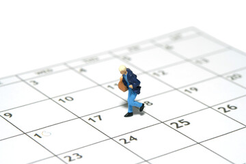 Miniature tiny people toy figure photography. A women student running above calendar schedule carrying duffle bag. Isolated on white background.