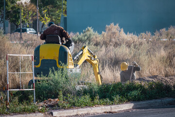 Workers with an excavator making a trench to place a connection to the gas network.