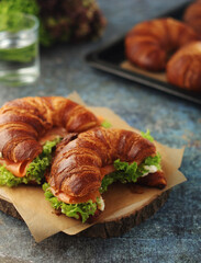 Freshly baked croissants with salmon and salad on the table
