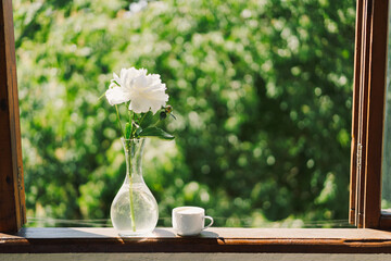 Cup coffee and white peonies on a wooden window. Romantic concept. Vintage style