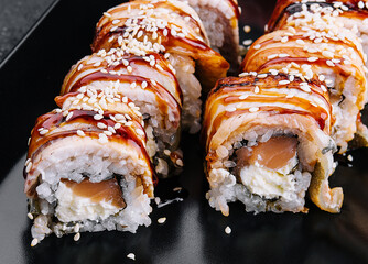 Sushi eel roll maki on black plate © AntAlexStudio