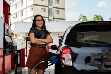 Obraz na płótnie Canvas Attractive young woman refueling car at gas station. Female filling diesel at gasoline fuel in car using a fuel nozzle. Petrol concept.