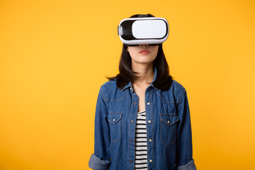 Young asian woman get experienced wearing virtual reality headset game entertainment isolated on yellow background. Winner of cyber future video game concept.