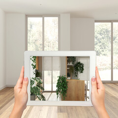 Augmented reality concept. Woman hands holding tablet with AR application used to simulate furniture and design products in empty wooden interior, urban jungle kitchen