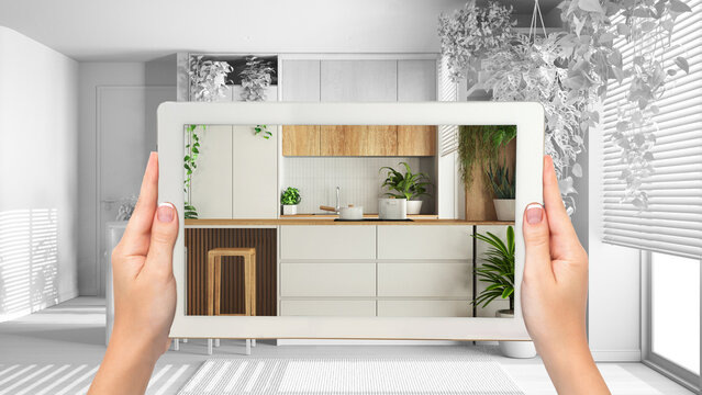 Augmented reality concept. Woman hands holding tablet with AR application used to simulate furniture and design products in total white background, urban jungle kitchen